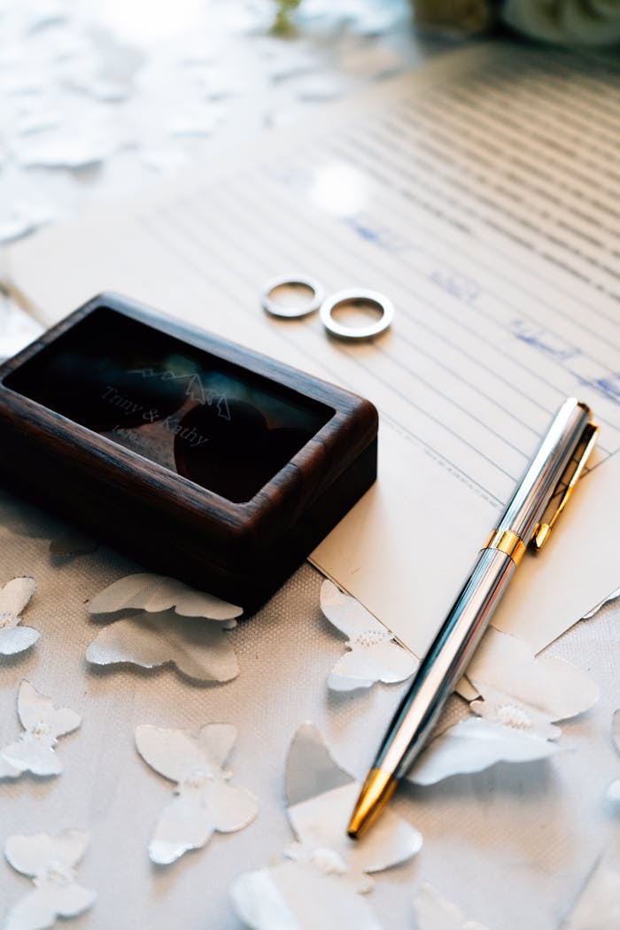 Elegant setup with a wedding certificate, rings, and pen symbolizing commitment and love.