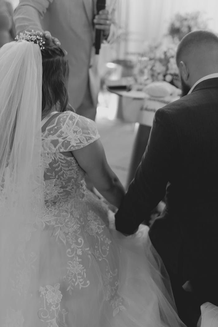 A black and white photo capturing a couple sharing a moment during their wedding ceremony.