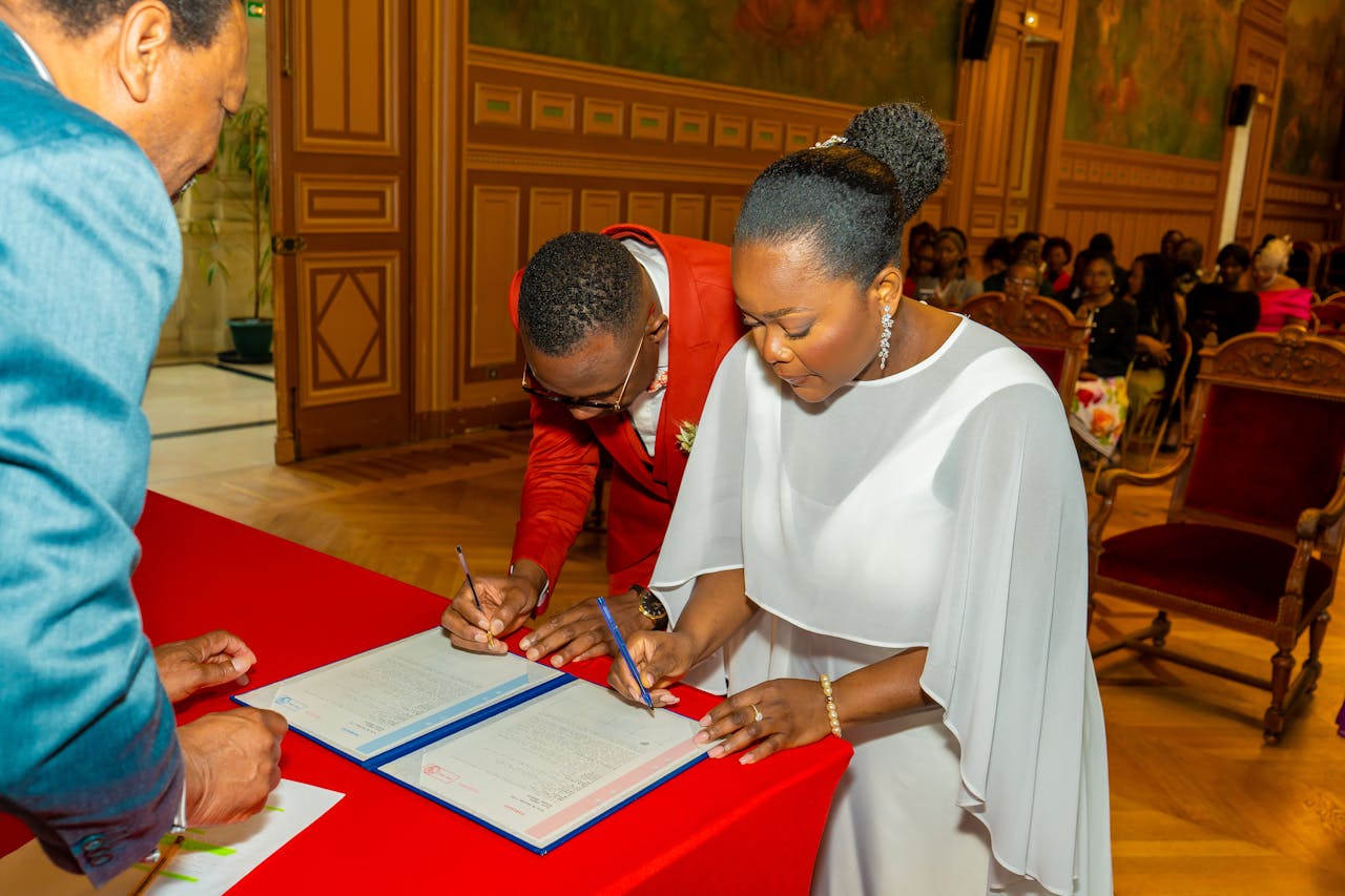 Bride and groom signing marriage documents with elegant decor
